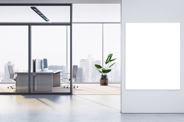 Modern office interior with blank vertical poster frame on white wall and city view through glass...