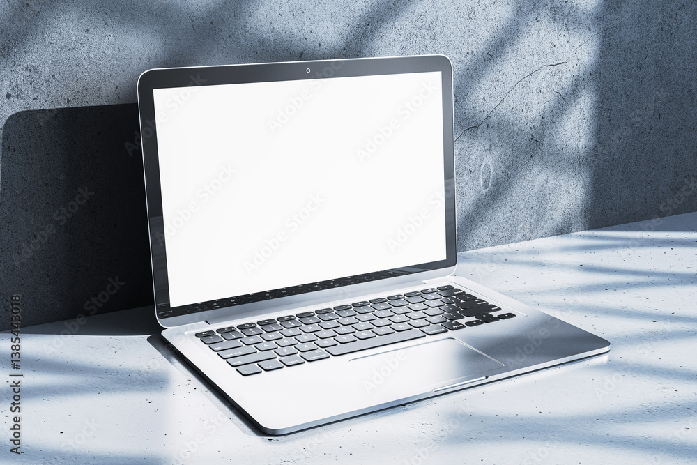 Poster modern laptop with blank white screen on minimalist desk against concrete wall in sunlight, ideal fo