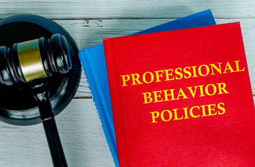 Top view of Professional Behavior Policies book with gavel background
