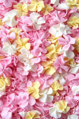 vibrant and dreamy scene of pastel colored fabric flowers in pink, yellow, and white creates whimsical and cheerful atmosphere. soft textures and colors evoke sense of joy and celebration