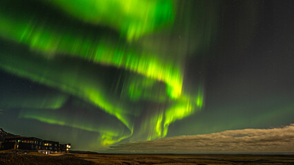 Aurora Borealis in Island, grüne Polarlichter tanzen über den Nachthimmel, durch den Vollmond...