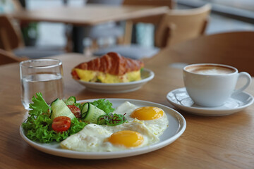 Delicious breakfast served on wooden table in cafe, closeup