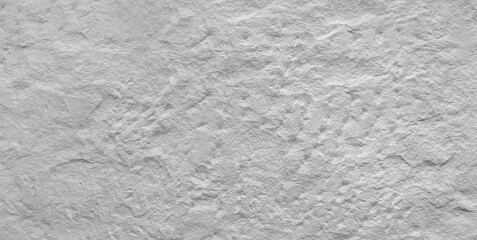 A large white wall with a grey texture. The wall is made of stone and has a rough surface
