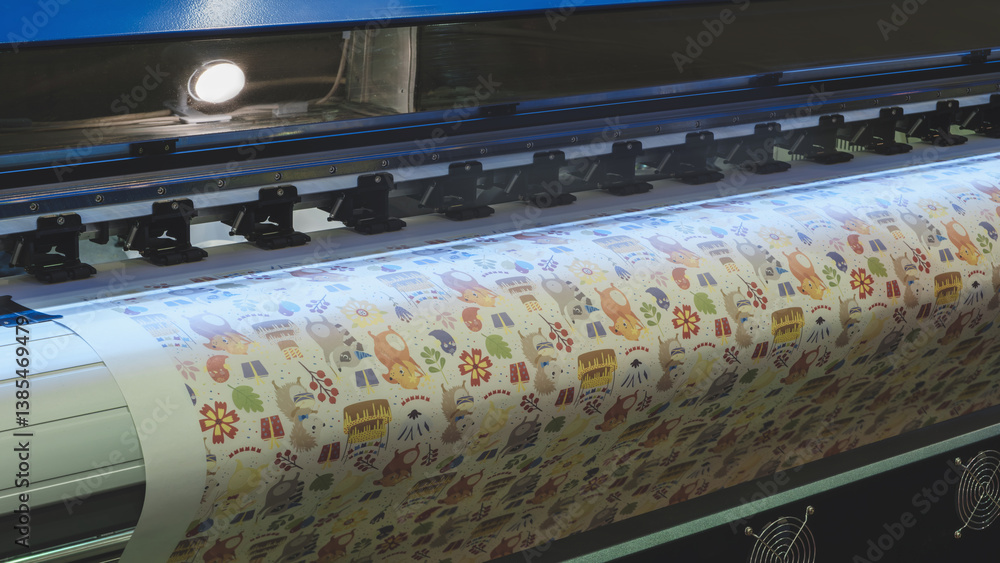 Poster a large printer is printing a colorful design with animals and flowers. the printer is in a dark roo