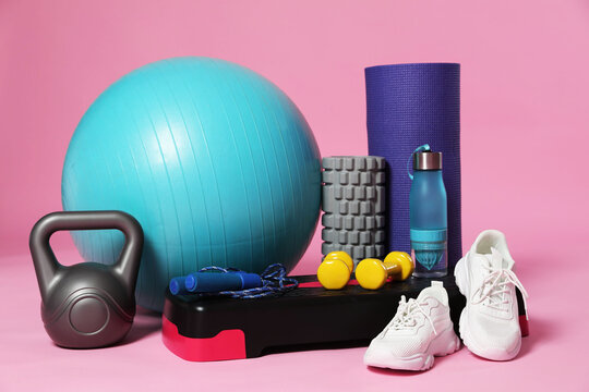 Many different fitness equipment on pink background