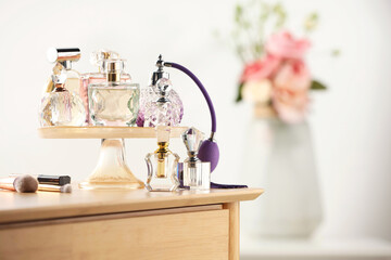 Different luxury perfumes on wooden dressing table indoors, space for text