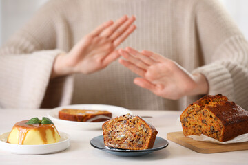 Woman refusing to eat products at table indoors, selective focus. Food allergy concept