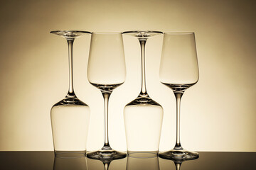 Many empty clean glasses on mirror surface against beige background