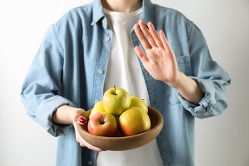 Woman refusing to eat apples on white background, closeup. Food allergy concept