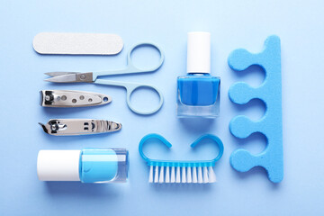Set of different manicure tools on light blue background, flat lay