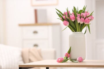 Bouquet of beautiful tulips in vase on wooden table indoors, space for text