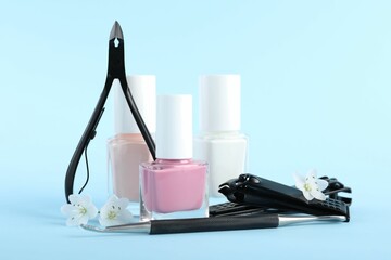 Set of different manicure tools on light blue background, closeup