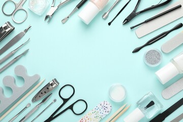 Frame of different manicure tools on turquoise background, flat lay. Space for text