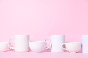 Different cups on pink background. Space for text