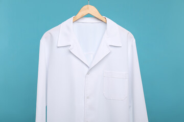 Doctor's coat on hanger against blue background