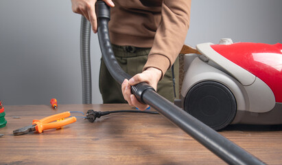 Caucasian master repairing vacuum cleaner. Vacuum cleaner repairing