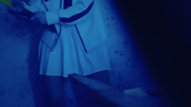 A furious girl smashes objects with an axe in a dark basement.