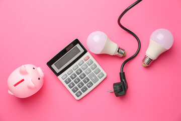 Piggy bank, calculator, light bulbs and plug on pink background, flat lay. Energy saving concept
