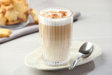Tasty latte macchiato in glass on white table, closeup. Coffee drink