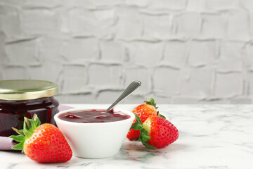 Delicious strawberry sauce and fresh berries on white marble table. Space for text