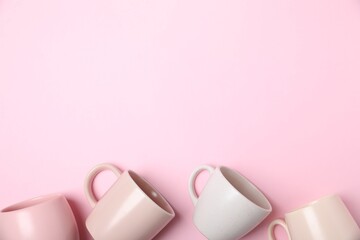 Many colorful cups on pink background, flat lay. Space for text