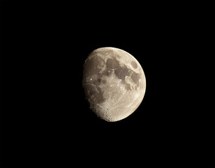 Obraz premium illuminated half moon against dark sky showcasing craters and lunar textures