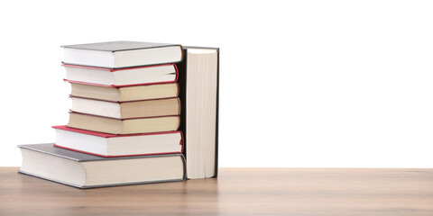 Stack of old books on wooden table against white background