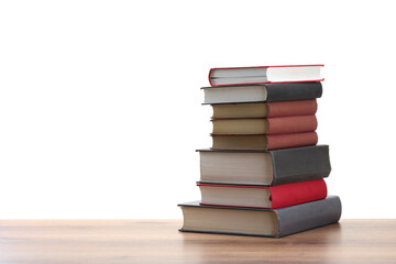 Stack of old books on wooden table against white background