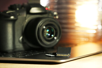 SD memory cards, laptop and photo camera on table, closeup