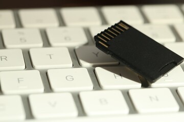 SD memory card on computer keyboard, closeup
