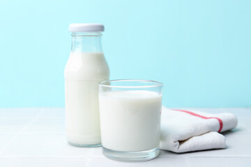 Fresh milk on white table against light blue background