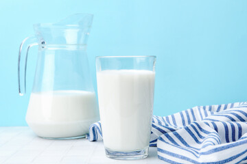 Fresh milk on white table against light blue background