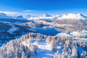 A stunning snowy landscape featuring a lake surrounded by mountains and evergreen trees under a clear blue sky.