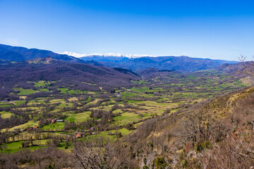 Fototapeta premium Panorama of Pic des Trois Seigneurs on the horizon and the Douctouyre Valley from the Ariège village of Roquefixade in spring