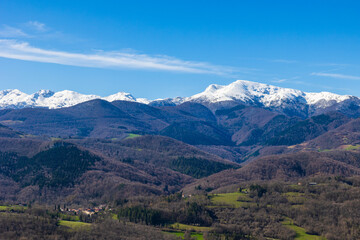 Panorama of the snowy Massif de Tabe with Mont Fourcat on the horizon and the Douctouyre Valley from the Ariège village of Roquefixade in spring