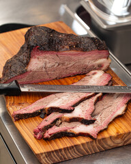 Closeup on sliced smoked american beef brisket on a wooden board