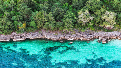 Breathtaking aerial shot of a tropical island’s rocky coastline and crystal clear turquoise waters. summer background and summer holiday concept.