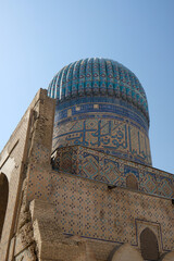 blue dome and walls with brightly colored mosaics of madrasah against blue sky, Samarkand