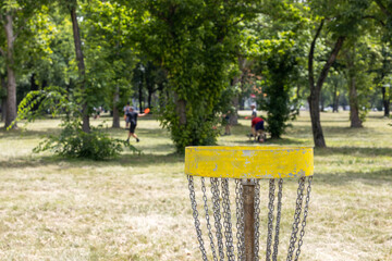 People playing frisbee flying disc golf sport game in the city park