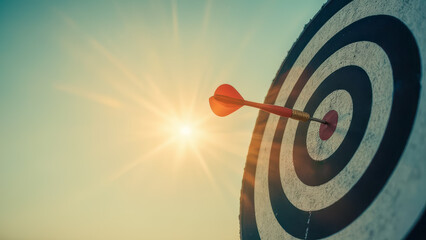 Precision and Accuracy Concept with Dart Hitting Target Board Against Bright Sunrise Background