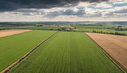 Aerial view of agricultural land with dynamic sky and patchwork fields