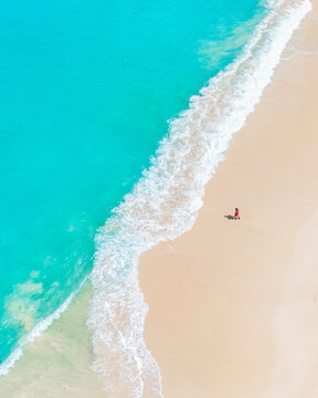 Breathtaking seascape of turquoise ocean waves caressing a soft white sandy shore in summer.