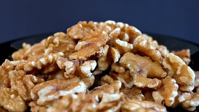 Close up static shot footage shows walnuts rotating on a plate.
