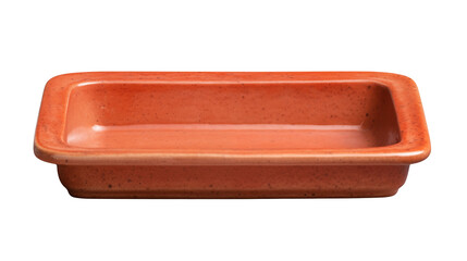 A terracotta rectangular baking dish isolated on a black background in studio lighting