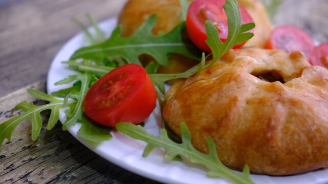 Mongolian buuz, dumplings with meat, savory fried dumplings filled with juicy meat, served on a plate with herb, arugula, tomatoes. Artisanal food