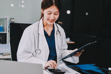 Medical health clinic beautiful Asian doctor working using smart tablet touching, stethoscope...
