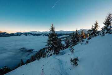 Winter hiking to Sina in Low Tatras National park near jasna is full of beautiful views. Sunset in Slovakia mountains with Chopok peak.