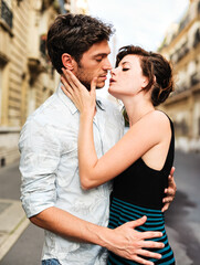 Young man and woman lovers kissing on Paris France street