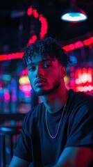 Fototapeta premium a young man sitting in a bar with neon lights. 