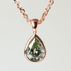 Fototapeta premium Elegant Pear-Shaped Green Gemstone Pendant on Rose Gold Chain